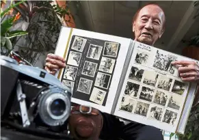  ?? — ZHAFARAN NASIB/The Star ?? ‘A great day’: With his old camera in the foreground, Hwang points to a photograph of Prince Philip in his album of prized snapshots taken during the Duke’s historic visit to Malaysia.