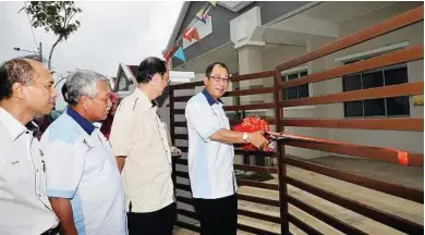  ??  ?? Official opening: Chor cutting the ribbon to a new house in Taman Cahaya Kota Putri in Plentong, Johor Baru, yesterday. Looking on are (from left) Johor Baru Mayor Burhan Amin, Housing and Local Government Ministry secretary-general Datuk Seri Ahmad...