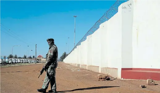  ?? Picture: SIPHIWE SIBEKO/REUTERS ?? TAKING PRECAUTION­S: A soldier keeps watch outside the Internatio­nal Pentecost Holiness Church where five people were killed in the attack in Zuurbekom