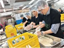  ??  ?? 2018年，環滙亞太與惜食堂合作，組織公司義工回收仍可­安全食用的剩餘食物，陳國輝（右）協助處理食物。（圖片由被訪者提供）