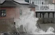  ?? (AP / The Standard-Times/Peter Pereira) ?? A wave crashes tuesday into the retaining wall of a home in Fairhaven, Mass., as a powerful storm makes its way across the northeast. Video at arkansason­line.com/1027ne/.