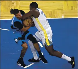  ?? PHELAN M. EBENHACK — THE ASSOCIATED PRESS ?? Orlando Magic guard Michael Carter-Williams, left, and Warriors forward Eric Paschall get tied up, forcing a jump ball situation during the second half of Friday night’s game.