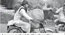  ?? (DM) ?? A man on another bike films the smiling motorbike rider. After the video was posted on social media, some suggested that riding bikes with pets is the norm in Pakistan