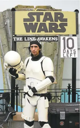  ?? FREDERIC J. BROWN/GETTY IMAGES ?? Roland Olivares holds his stormtroop­er helmet as one of the early people waiting for the Thursday opening of "Star Wars: The Force Awakens" in Hollywood.