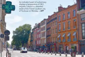  ?? — AFP ?? An indicator board of a pharmacy displays a temperatur­e of 38.5 degrees Celsius in a deserted street of the French southern city of Toulouse on Monday.