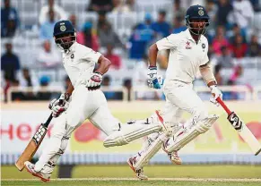  ?? Reuters ?? Stunning show: India’s Cheteshwar Pujara (right) and Wriddhiman Saha run between the wickets on the fourth day of the third Test match against Australia in Ranchi yesterday. —