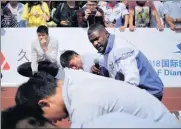  ?? ALYWIN CHEW/ CHINA DAILY ?? US sprinter Justin Gatlin interacts with students at Qibao Middle School in Shanghai on Thursday.