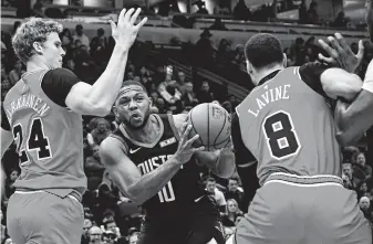  ?? Matt Marton / Associated Press ?? Rockets guard Eric Gordon (10) looks to split the defense of Bulls forward Lauri Markkanen (24) and guard Zach LaVine. Gordon returned from injury but came off the bench against Chicago.