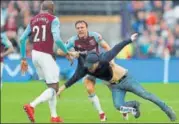  ?? REUTERS ?? West Ham players tackle a pitch invader on Saturday.