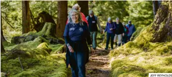  ?? JEFF REYNOLDS ?? Haida guide Gaajiiaawa leads guests through the forest at T’aanuu village site