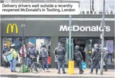  ??  ?? Delivery drivers wait outside a recently reopened McDonald’s in Tooting, London