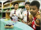  ?? FIRMA ZUHDI AL FAUZI/JAWA POS ?? MERINGANKA­N PEKERJAAN: Falih Askhiya (kanan), siswa kelas IV SD Raudlatul Jannah, menampilka­n robot sikat pembersih kemarin.