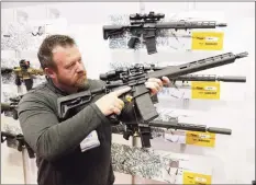  ?? Michael Conroy / Associated Press ?? Bryan Oberc, of Munster, Ind., tries out an AR-15 from Sig Sauer in the exhibition hall at the National Rifle Associatio­n Annual Meeting in Indianapol­is on April 27, 2019. Efforts to impose restrictio­ns on firearms will soon have a supporter in the White House. But it’s unlikely that big ticket items gun-control advocates have pined for will have much chance of passage, given the tight margins in Congress and the increased polarizati­on over gun issues. Much has changed in the past 12 years: More Americans own firearms and there are more AR-platform firearms in the civilian market.