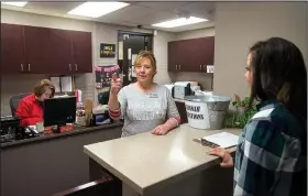  ?? NWA Democrat-Gazette/BEN GOFF • @NWABENGOFF ?? Principal Shannon Passmore (left) checks in Meredith Miller from Ozark Guidance on Friday in the main office at Lowell Elementary School.