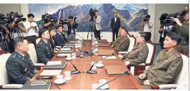  ??  ?? Towards peace: An (second on right) and Kim (second on left) discussing matters during the meeting at the border village of Panmunjom, South Korea. —