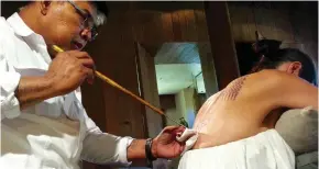  ??  ?? Jolie painful: Former Thai monk Ajarn Noo Kanpai inks her back