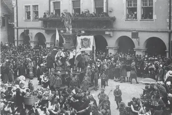  ?? FOTO/COPYRIGHT: FOTONACHLA­SS KUGLER_SUTTON VERLAG ?? 1933 beim Bräuteln auf dem Marktplatz: Auf dem Brunnen sind Trommler und Pfeifer der Bräutlings­gesellen mit der Narrenfahn­e zu sehen.