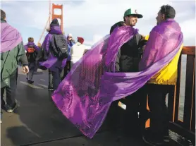  ?? Lea Suzuki / The Chronicle ?? John Rowe (right) and James Bosch take part in Bridge Together Golden Gate, in which about 3,000 people joined hands along the span’s east sidewalk.