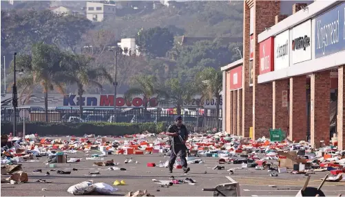  ?? | MOTSHWARI MOFOKENG African News Agency (ANA) ?? AN SAPS officer stands guard at Springfiel­d Mall near Umgeni Road in Durban after the shops there were looted. The poor will feel the adverse affects of the looting the most, says the writer.