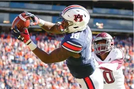  ?? AP Photo/ Todd Kirkland ?? ■ Auburn wide receiver Seth Williams (18) reaches a touchdown reception as Texas A&amp;M defensive back Myles Jones (10) defends during the second half Saturday in Auburn, Ala.