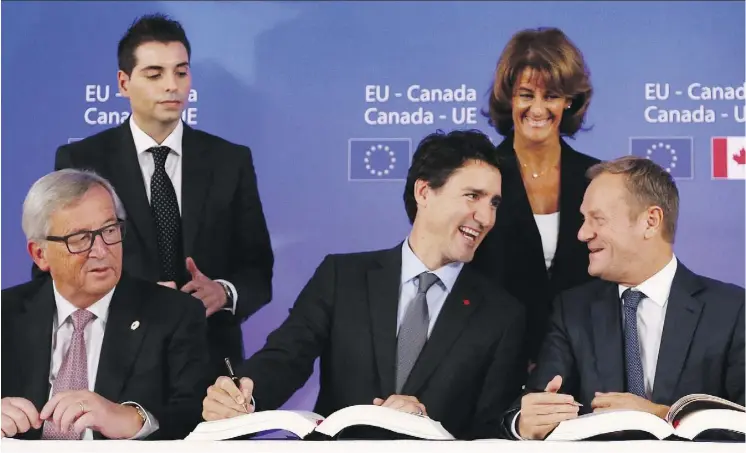  ?? FRANCOIS LENOIR/POOL PHOTO VIA AP FILES ?? Prime Minister Justin Trudeau, centre, signs CETA with European Commission President Jean-Claude Juncker, left, and European Council President Donald Tusk, right, in Brussels on Oct. 30, 2016. The new Canada EU Trade Investment Associatio­n will foster co-operation and dialogue among EU and Canadian businesses.