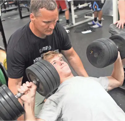  ?? CURT HOGG / NOW NEWS GROUP ?? Muskego safety Hunter Wohler works on his dumbbell press during an off-season workout in July 2019.