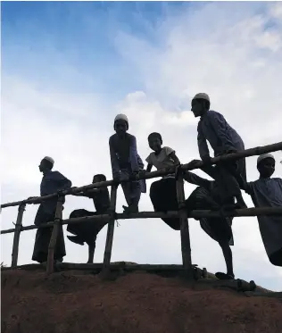  ?? DIBYANGSHU SARKAR / AFP / GETTY IMAGES ?? Young Rohingya refugees gather next to a bamboo railing while looking at a road below at Kutupalong refugee camp in Bangladesh on Wednesday.