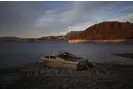  ?? Photograph: John Locher/AP ?? A formerly sunken boat sits high and dry along the shoreline of Lake Mead in May.