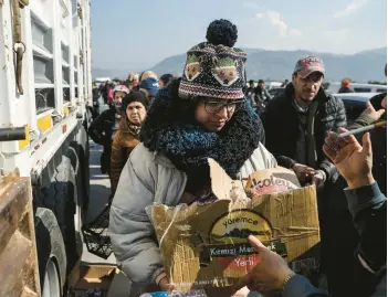  ?? BURAK KARA/GETTY ?? People affected by the earthquake line up to receive food and goods Monday in Samandag, Turkey.