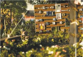  ?? John Locher / Associated Press ?? Photos of Las Vegas shooting victims hang ata memorial garden in Las Vegas. The small garden, a place to mourn and heal, is the only permanent public space created in memory of the 58 people who were killed.