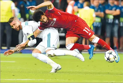  ??  ?? Momento en el que Sergio Ramos comete una falta a Mohamed Salah, estrella del Liverpool, que derivó en la lesión del egipcio, quien debió abandonar el partido y está en duda para asisitir al Mundial de Rusia ■ Foto Jam Media