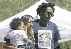  ??  ?? Salena Manni, the fiancee of police shooting victim Stephon Clark, holds the couple’s son, Aiden, as she and Clark’s uncle, Curtis Gordon attend a rally Saturday.