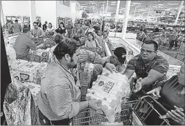  ?? [ROBERTO KOLTUN/MIAMI HERALD] ?? A long line waits to buy items Tuesday at BJ Wholesale of Hurricane Irma hitting Florida. in Miami in anticipati­on