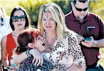  ?? JOEL AUERBACH/AP ?? Parents wait for news after a mass shooting Feb. 14 at Marjory Stoneman Douglas High School in Parkland, Fla