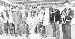  ??  ?? MUSBAH (kanan) mengetam padi sebagai gimik perasmian Pesta Kaamatan Kg Bugaron sambil diperhatik­an James (kiri).