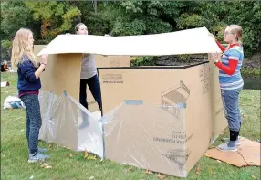  ?? Janelle Jessen/Herald-Leader ?? Three girls from Compass Church Youth Group worked on constructi­ng a place to sleep out of cardboard boxes on Friday evening.