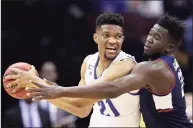  ?? Adam Hunger / Associated Press ?? Seton Hall center Ike Obiagu, left, looks to pass around UConn’s Adama Sanogo during the first half Saturday in Newark, N.J.