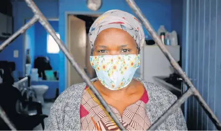  ?? REUTERS ?? Domestic worker Alphonia Zali looks out from her two roomed apartment, as authoritie­s around the world impose various guidelines on lockdowns and social distancing to curb the spread of COVID-19, in Langa township near Cape Town, South Africa, on May 7.