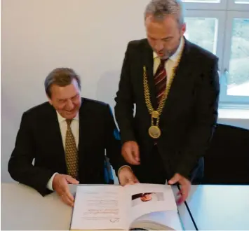  ?? Foto: Unflath ?? Ein Höhepunkte seiner Amtszeit als Bürgermeis­ter in Tagmershei­m: Der Besuch des ehemaligen Bundeskanz­lers Gerhard Schröder 2011 - hier beim Eintrag in das goldene Buch. Georg Schnell denkt gerne daran zurück.