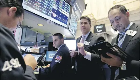  ?? RICHARD DREW / THE ASSOCIATED PRESS FILES ?? NYSE governor Richard Barry, second from right, with traders at the post that handles Valeant on the floor of the New York Stock Exchange in October. Valeant’s stock has plummeted more than 84 per cent in the past 12 months.