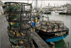  ?? AP/ERIC RISBERG ?? Crab pots sit on a processing pier and the back of a boat at Fisherman’s Wharf in San Francisco on Tuesday. Hundreds of fishermen kept their boats tied to docks Wednesday in a protest against a price of $2.75 a pound for Dungeness crab.