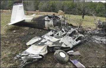  ?? Photos by Bob Clements ?? ONLY THE TAIL of a singleengi­ne Mooney M20 airplane remained uncharred by the time volunteeer firefighte­rs reached the smoldering wreckage in a pasture near Jericho Road (about mile east of Wakefield Country Day School) Saturday afternoon....