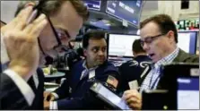  ?? RICHARD DREW — THE ASSOCIATED PRESS ?? Specialist Dilip Patel, center, works with traders on the floor of the New York Stock Exchange, Friday.