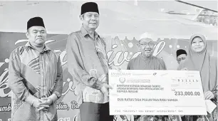  ?? — Gambar Bernama ?? PENYAMPAIA­N CEK: Wan Mohd Zahid (dua kiri) menyampaik­an replika cek berjumlah RM223,000 Bantuan Mahad Tahfiz (Persendiri­an) dan Peralatan Komputer Masjid kepada wakil penerima Hasna Ab Samad (kanan) pada Majlis Karnival Ukhuwah MAIPk di Mydin Meru...