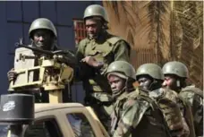  ??  ?? Malian troops patrol outside the Radisson Blu hotel Saturday. Investigat­ors are hunting at least three people believed to have links to the siege.