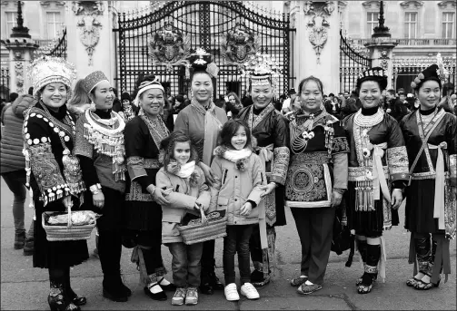  ?? PHOTOS PROVIDED TO CHINA DAILY ?? Embroidere­rs pose outside Buckingham Palace as they see the sights in London on Dec 7 during an exhibition of their traditiona­l handicraft­s.