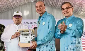  ??  ?? Doing their bit: Abdul Rahman (left) receiving a souvenir from Lee while Liew looks on after the launch of the walk in Penang.