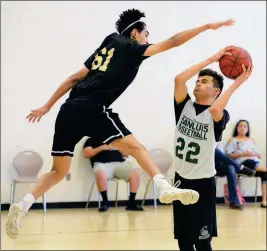  ??  ?? CIBOLA’S ADRIAN HERNANDEZ (61) gets up in the air while trying to stop a drive to the basket by San Luis’ Jonathan Badilla during their opening-round game Wednesday at Gila Ridge.