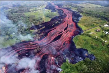  ?? U.S. GEOLOGICAL SURVEY VIA AP, FILE ?? In this file photo released by the U.S. Geological Survey, lava flows from fissures near Pahoa, Hawaii. Technicall­y speaking, Kilauea has been continuous­ly erupting since 1983. But the combinatio­n of earthquake­s shaking the ground, steam-driven...