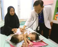  ?? ROBERTUS RISKY/JAWA POS ?? SIAPKAN KONDISI: Dokter
Agus Harianto SpA memeriksa kondisi bayi kembar siam di RSUD dr Soetomo kemarin.